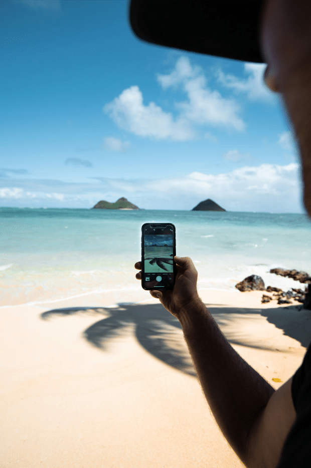 Image d'une personne qui prends en photo l'ombre d'un cocotier, communication 360°